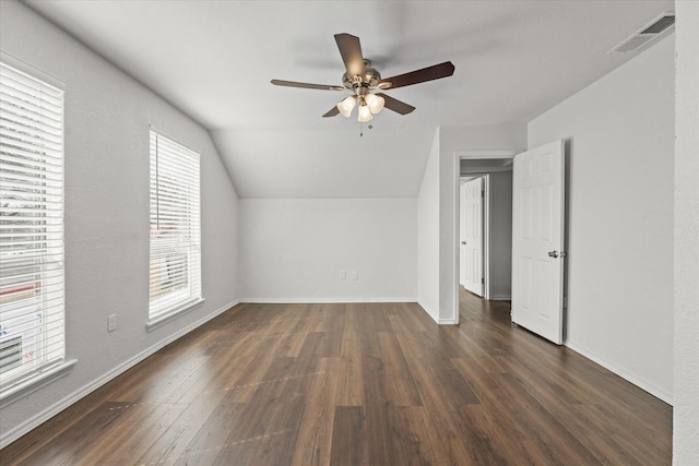 interior space featuring baseboards, visible vents, lofted ceiling, ceiling fan, and dark wood-type flooring