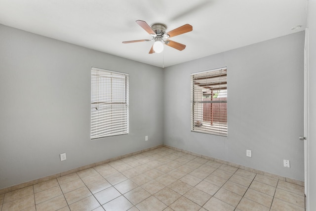 spare room featuring a ceiling fan and light tile patterned floors