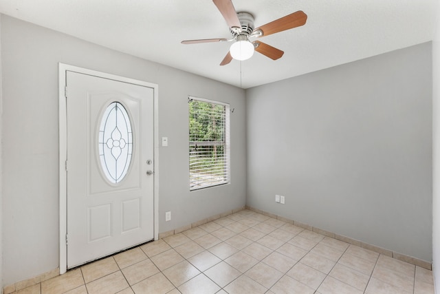 entryway featuring a ceiling fan, light tile patterned flooring, and baseboards