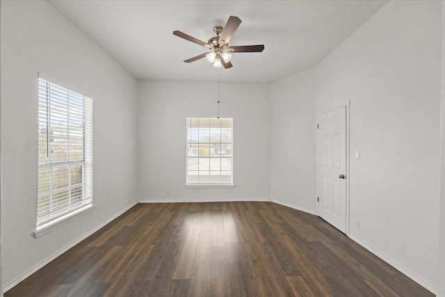 spare room with dark wood-style floors, baseboards, and a ceiling fan