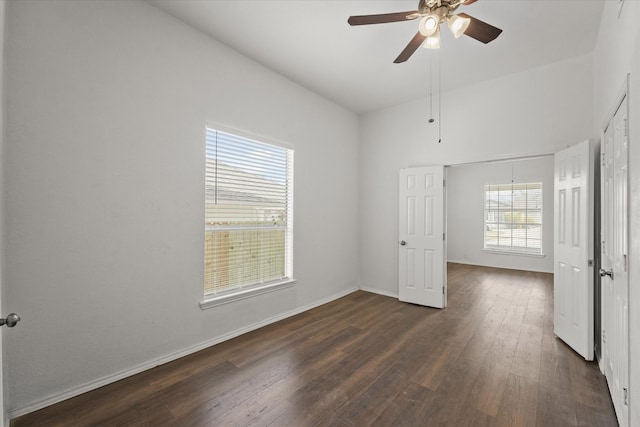 unfurnished bedroom featuring dark wood finished floors, a ceiling fan, and baseboards