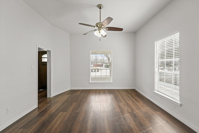 spare room featuring dark wood-style floors, ceiling fan, and baseboards