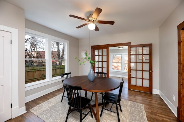 dining room featuring baseboards, dark wood finished floors, and a ceiling fan