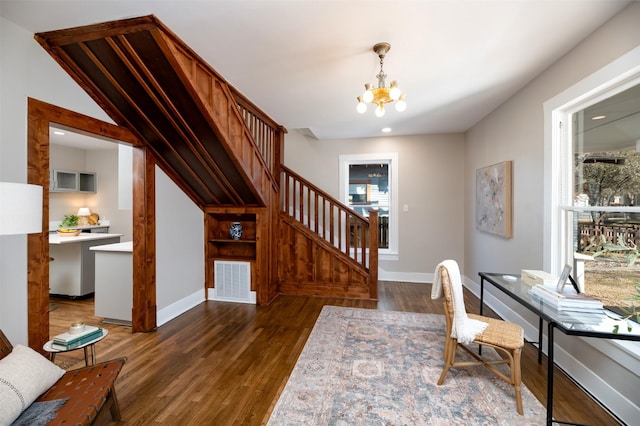 home office with baseboards, wood finished floors, visible vents, and a notable chandelier