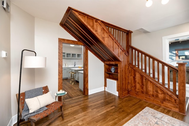 stairs featuring baseboards, visible vents, and wood finished floors