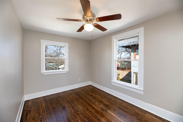 unfurnished room with ceiling fan, baseboards, and dark wood-type flooring