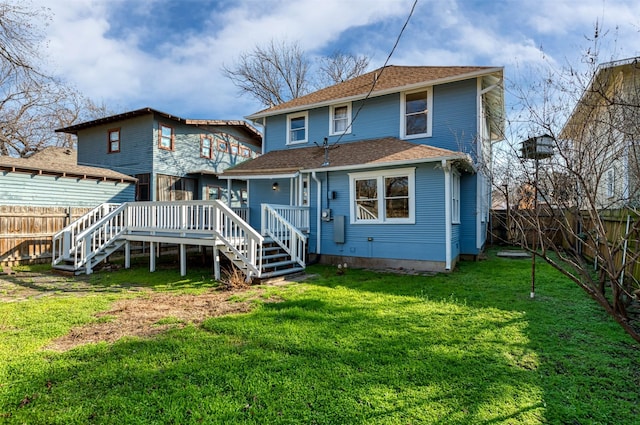 back of house featuring stairway, a fenced backyard, a lawn, and a deck