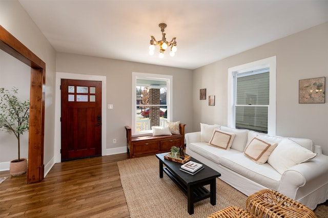 living area with a chandelier, wood finished floors, and baseboards