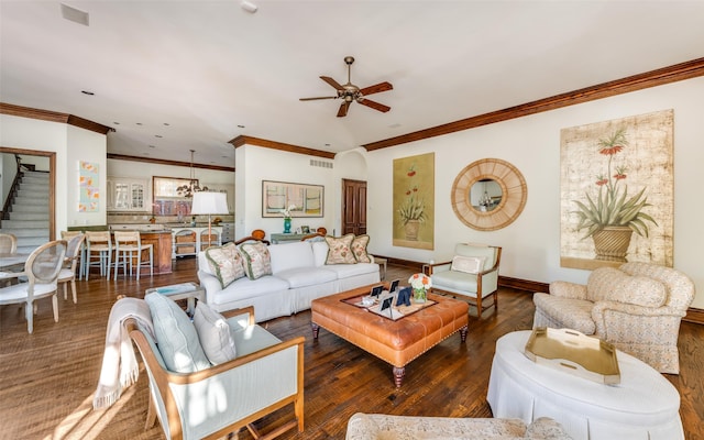 living area with ornamental molding, ceiling fan, wood finished floors, baseboards, and stairs