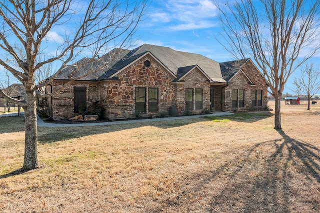 view of front of property with a front yard, stone siding, and brick siding