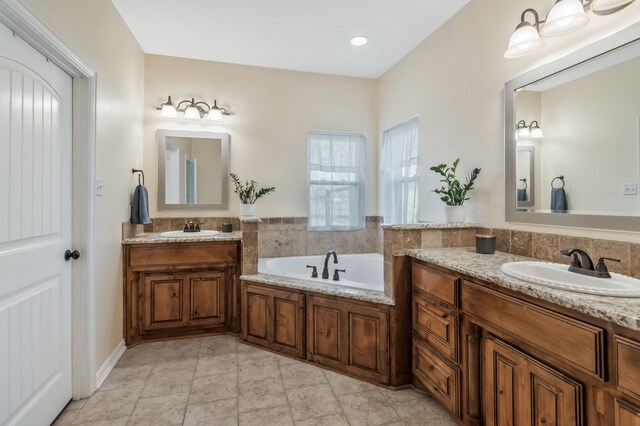 full bath featuring a garden tub, two vanities, a sink, and tile patterned flooring