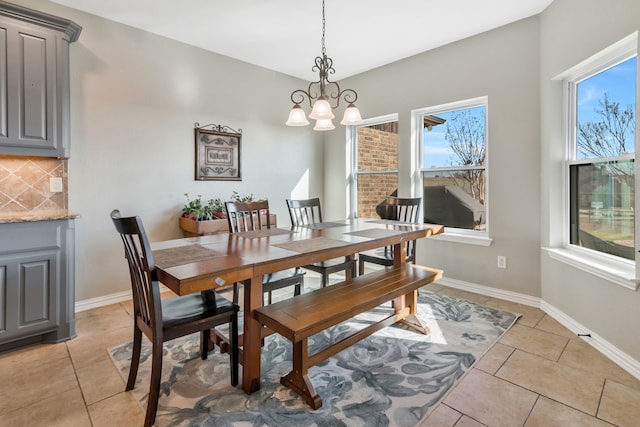 dining room with light tile patterned floors, a chandelier, and baseboards