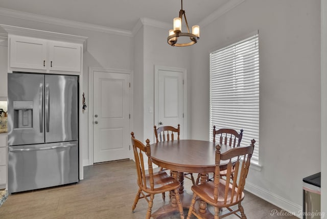 dining space featuring light wood-style floors, baseboards, a chandelier, and crown molding