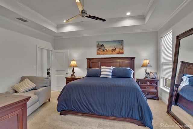 bedroom with visible vents, a tray ceiling, crown molding, and light colored carpet