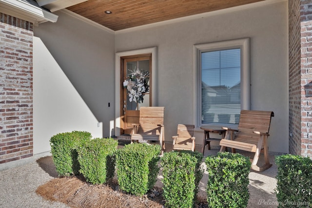 entrance to property featuring brick siding and stucco siding