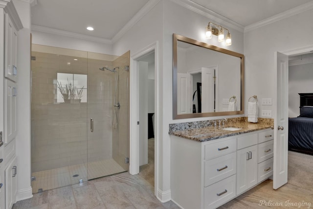 ensuite bathroom with crown molding, ensuite bathroom, a shower stall, vanity, and baseboards