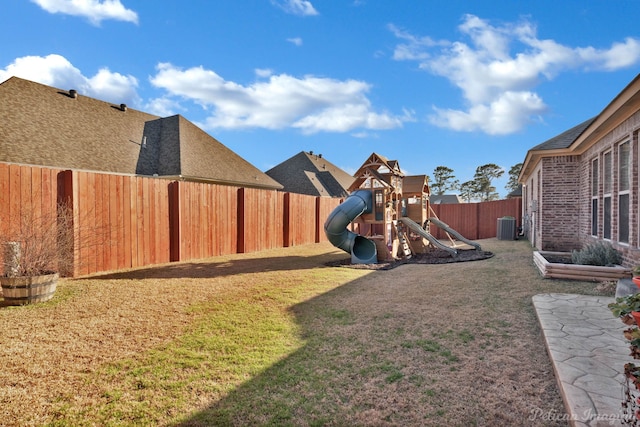 view of playground featuring a lawn, a fenced backyard, and central air condition unit