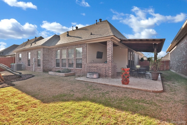 rear view of house with central AC unit, a fenced backyard, a yard, a patio area, and brick siding