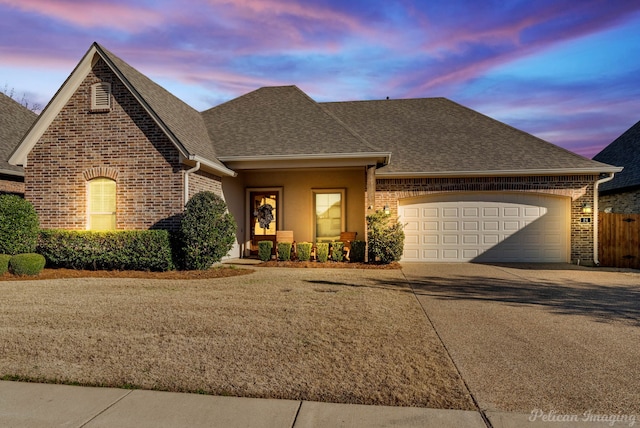 view of front of property with a shingled roof, concrete driveway, brick siding, and an attached garage