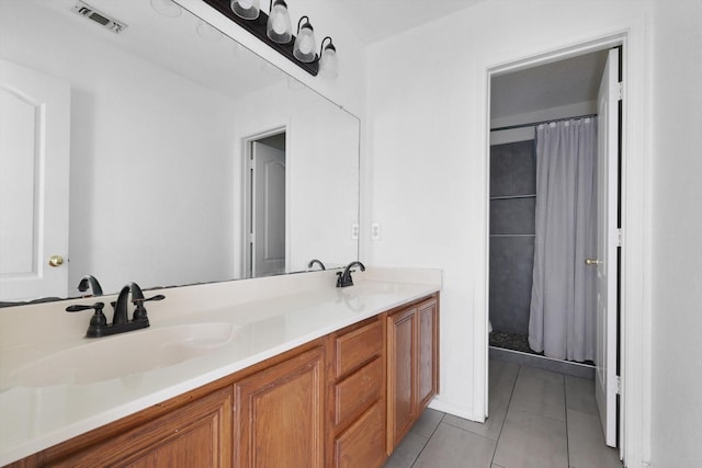 bathroom featuring tile patterned flooring, visible vents, a sink, and double vanity