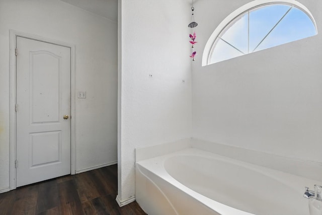 full bath with a bath and wood finished floors