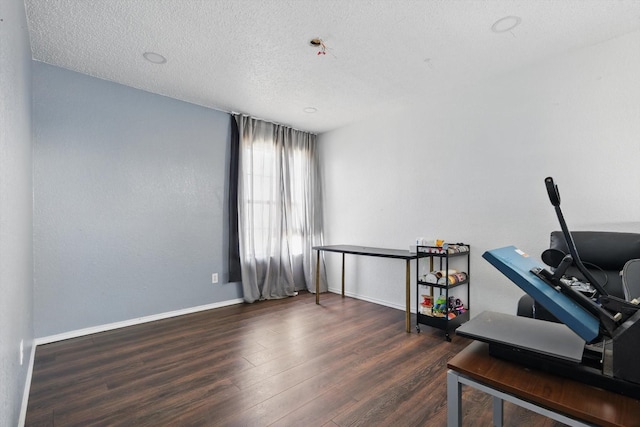 office with a textured ceiling, baseboards, and wood finished floors