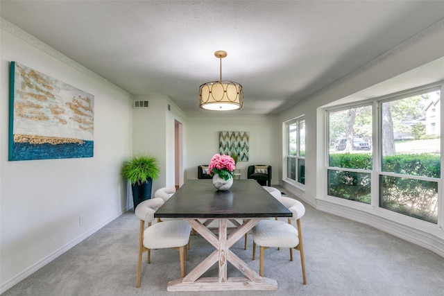 dining space featuring baseboards, visible vents, and light colored carpet