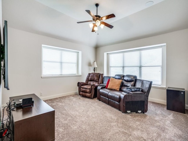 carpeted living area featuring lofted ceiling, a ceiling fan, and baseboards