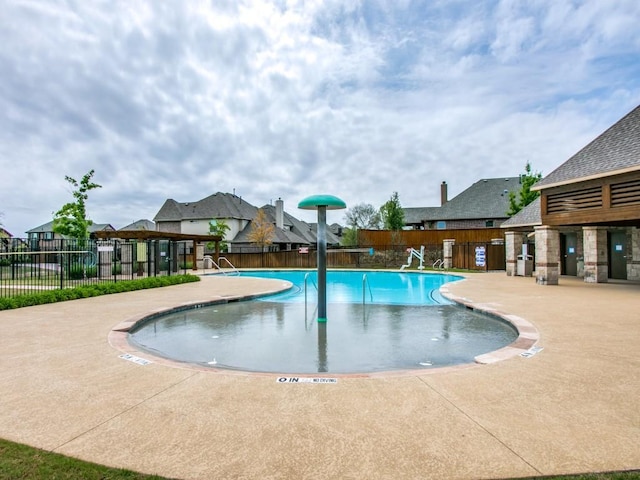 community pool featuring a patio and fence