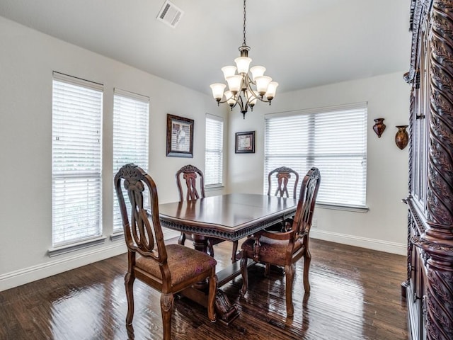 dining room with dark wood-style floors, a chandelier, visible vents, and baseboards