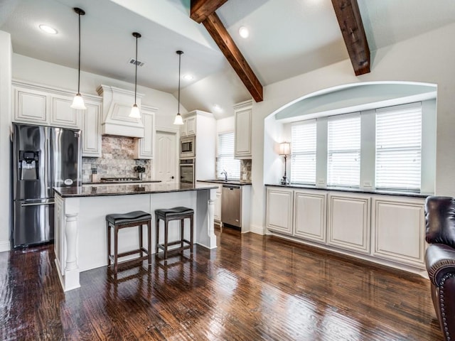 kitchen with custom exhaust hood, backsplash, lofted ceiling with beams, appliances with stainless steel finishes, and a kitchen breakfast bar