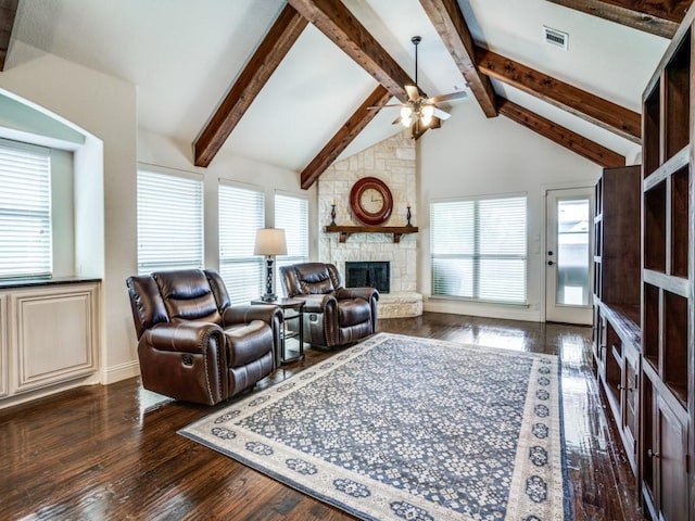 living area with vaulted ceiling with beams, dark wood-type flooring, a fireplace, and visible vents