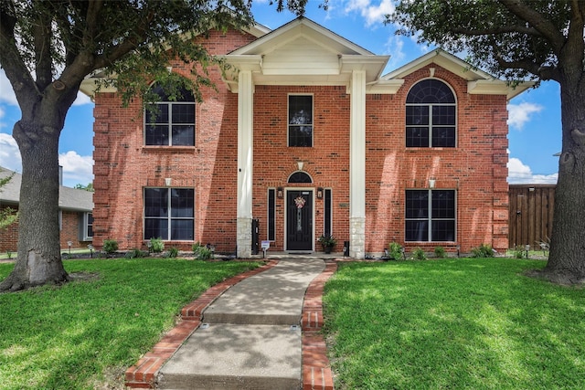 view of front of house featuring brick siding and a front lawn