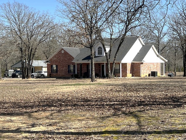 view of front of house with central air condition unit and brick siding