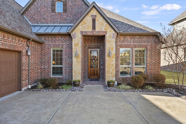 doorway to property with stone siding, brick siding, a standing seam roof, and a shingled roof