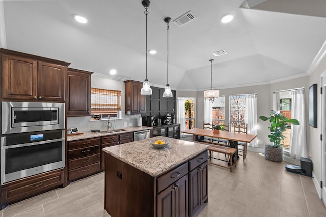 kitchen featuring a center island, visible vents, decorative backsplash, appliances with stainless steel finishes, and a sink