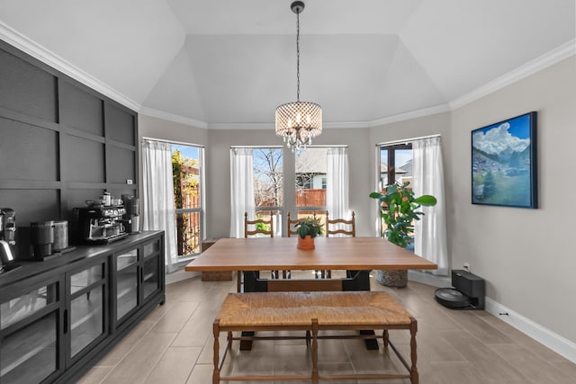 dining room with a chandelier, lofted ceiling, ornamental molding, and baseboards