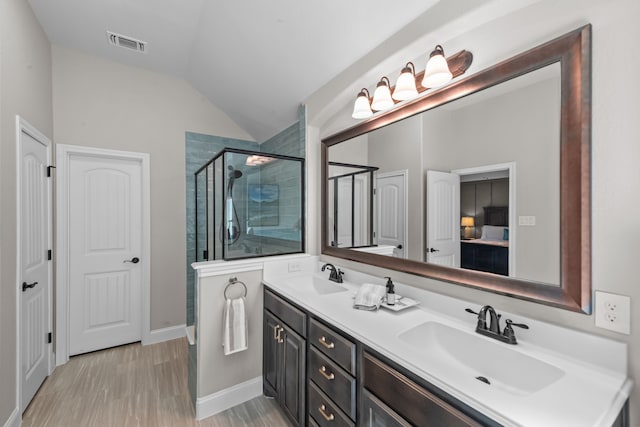 bathroom with vaulted ceiling, a stall shower, a sink, and visible vents