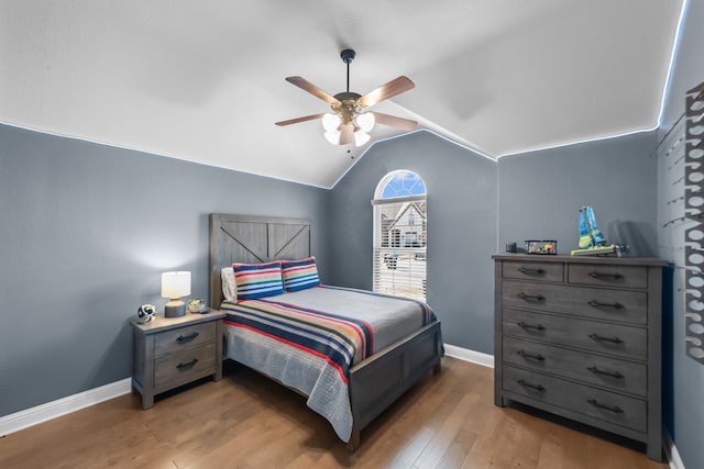 bedroom with light wood-type flooring, ceiling fan, baseboards, and lofted ceiling