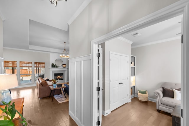 sitting room featuring visible vents, crown molding, and hardwood / wood-style flooring