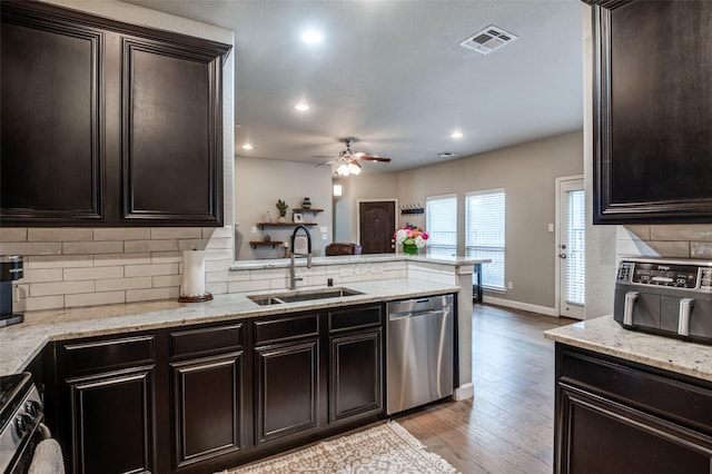 kitchen with visible vents, decorative backsplash, appliances with stainless steel finishes, a peninsula, and a sink