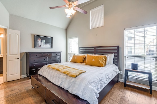 bedroom featuring high vaulted ceiling, baseboards, and wood finished floors