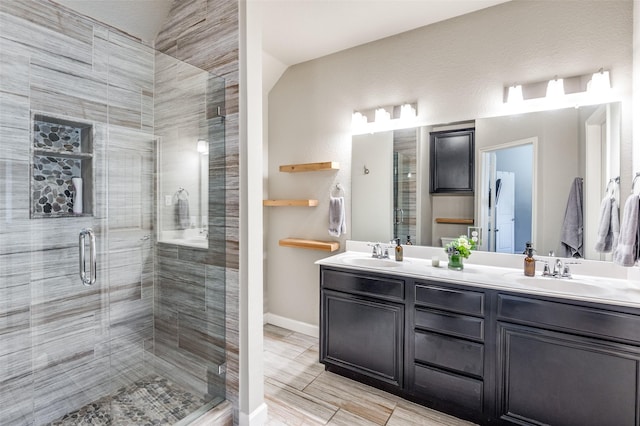 bathroom with a stall shower and a sink