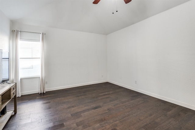 unfurnished room with a ceiling fan, baseboards, and dark wood-type flooring