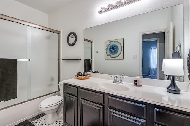 full bathroom with combined bath / shower with glass door, tile patterned flooring, vanity, and toilet