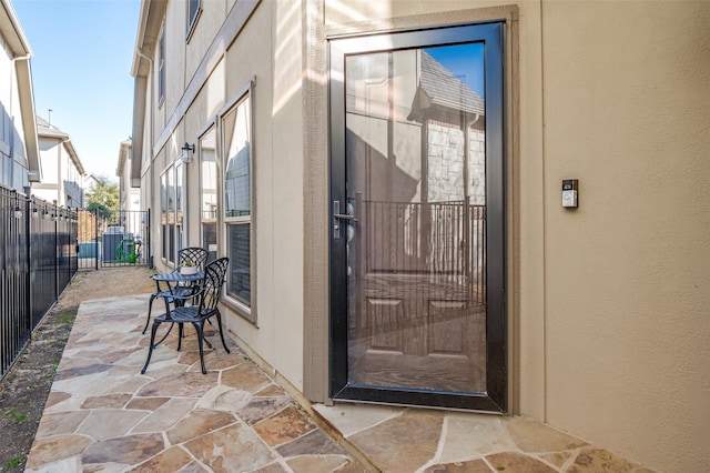 doorway to property featuring a patio area and fence