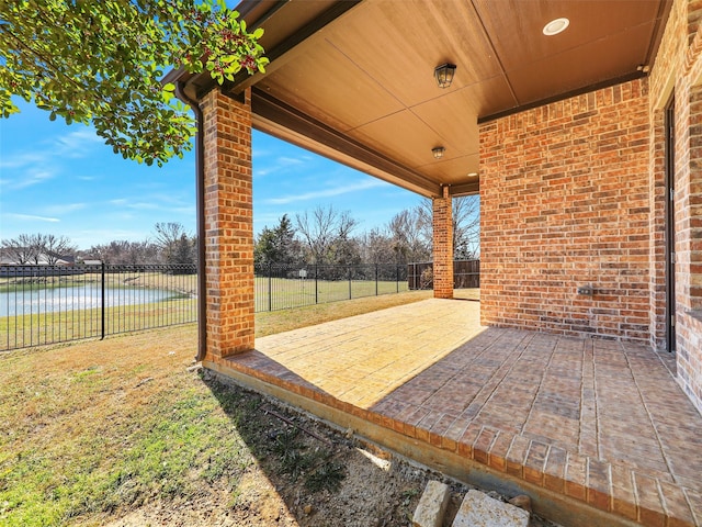 view of patio with a fenced backyard and a water view