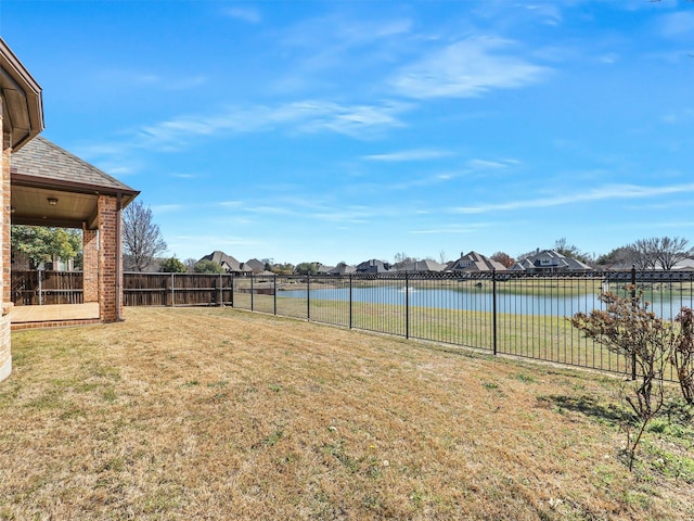 view of yard with a water view and fence