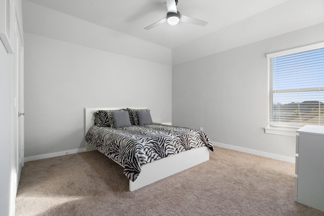 carpeted bedroom with a ceiling fan and baseboards