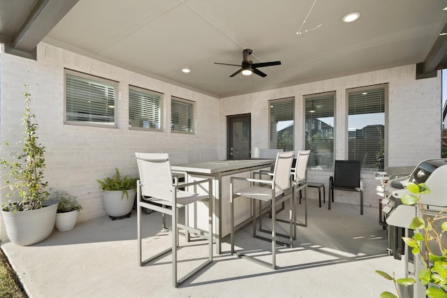 view of patio with outdoor dining area and a ceiling fan